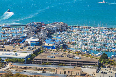 High angle view of houses by sea against blue sky