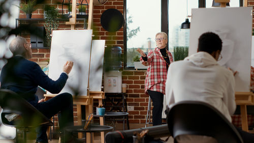 Artist pointing towards students in classroom