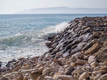 Scenic view of rocks in sea against sky