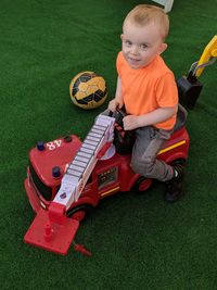 High angle portrait of boy playing with toy vehicle