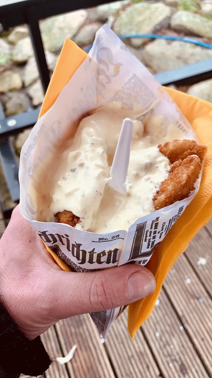 CLOSE-UP OF HAND HOLDING ICE CREAM WITH BREAD