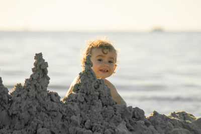 Portrait of boy on rock at beach