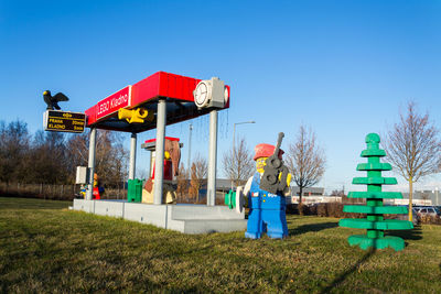 Lifeguard hut on field against clear blue sky