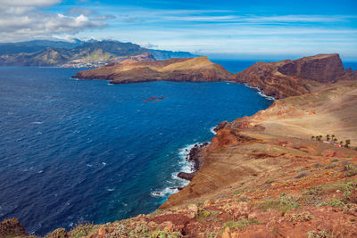 Scenic view of sea and mountains against sky