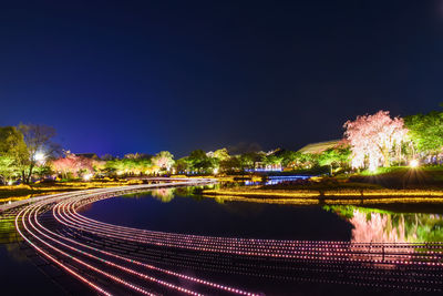 Light trails in city against sky at night