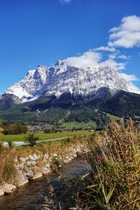 Scenic view of snowcapped zugspitze mountain against blue sky