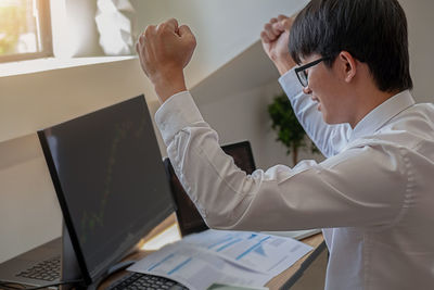 Midsection of man using laptop on table