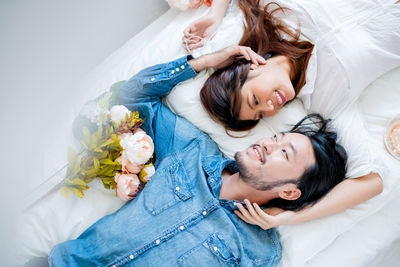 High angle view of couple embracing on bed