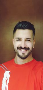 Portrait of smiling man against brown background