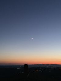 Silhouette city against sky at sunset