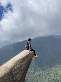 Low angle view of man jumping on sea against sky