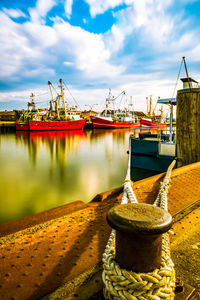 Ship moored at harbor against sky