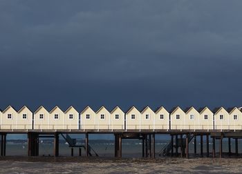 Houses on beach by sea against sky