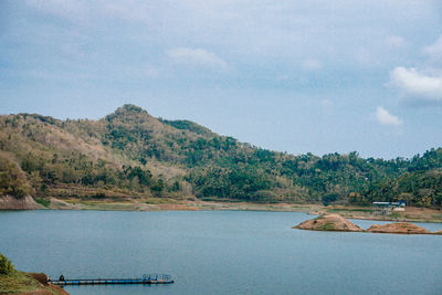 Scenic view of lake by trees against sky