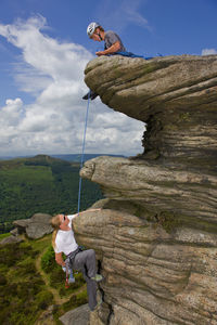 Two friends are climbing at stanage edge in the peak district