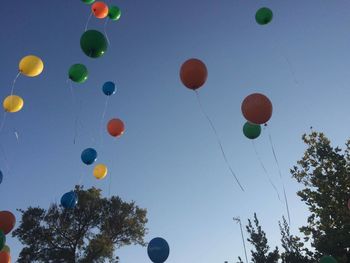 Low angle view of balloons against blue sky