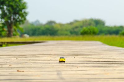 Yellow toy car on wooden bridge