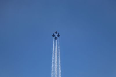 Low angle view of airplane flying against clear blue sky