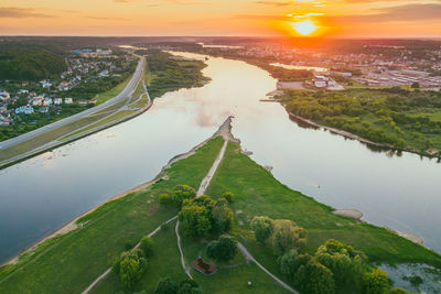 High angle view of river amidst cityscape during sunset