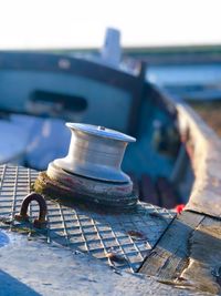 Close-up of metal on abandoned boat against sky