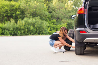 Rear view of woman on road against trees