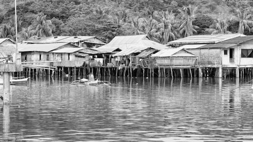 Houses by lake against buildings