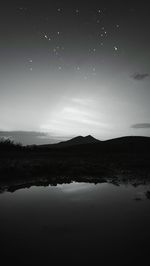 Scenic view of lake against sky at night