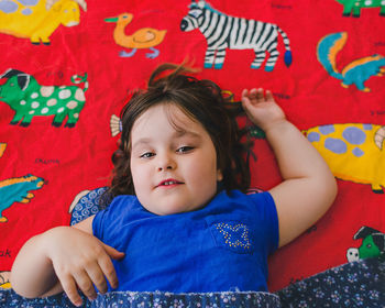 Portrait of happy cute girl relaxing on bed at home