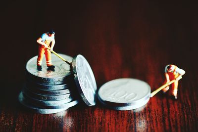 Close-up of figurine and coins on table