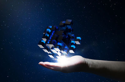 Digital composite image of woman touching cube shaped box in space