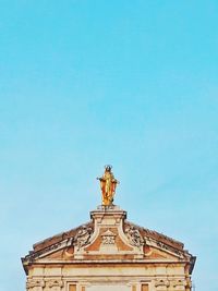 Low angle view of statue against blue sky