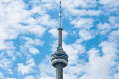 Low angle view of communications tower against cloudy sky