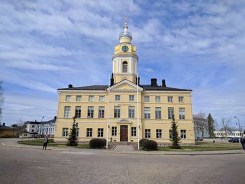 Low angle view of building against cloudy sky during sunny day