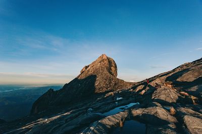 Panoramic view of rocks and mountains against blue sky