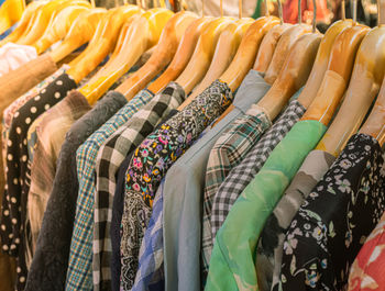 Row of multi colored clothes hanging on display at store