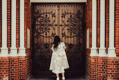 Rear view of woman standing in front of church portal