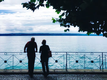 Rear view of couple looking at sea against sky