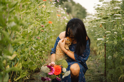 Portrait a woman stroking big red fluffy cat on nature. friendship people and animal.