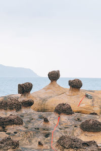 Rocks on beach against clear sky