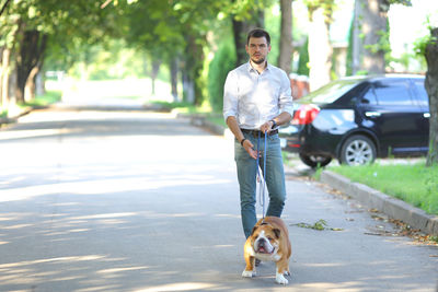 Side view of young woman with dog on street