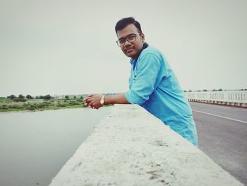 Portrait of smiling young man against sky