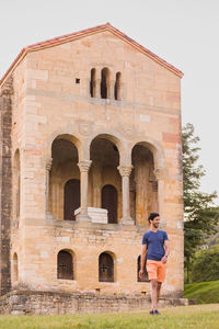 Rear view of woman standing against building