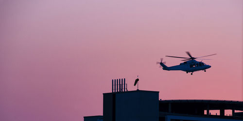 Low angle view of airplane flying against sky during sunset