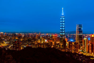 Illuminated buildings against sky at night