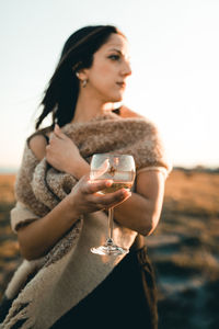 Young woman looking at camera against sky