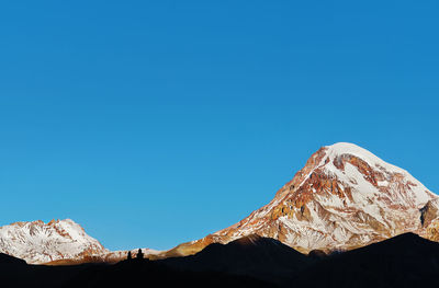 Mount kazbek in the rays of the morning sun, early autumn in the mountains. 