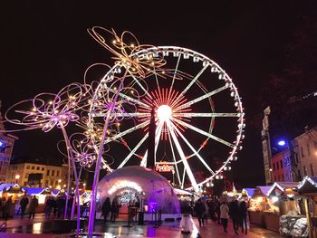 Low angle view of illuminated ferris wheel against sky at night