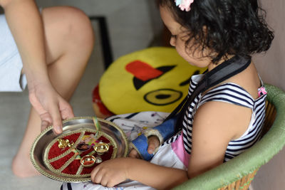 Midsection of woman holding girl at home