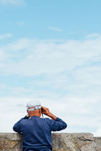 Rear view of man standing against sky