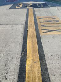 High angle view of yellow arrow symbol on road